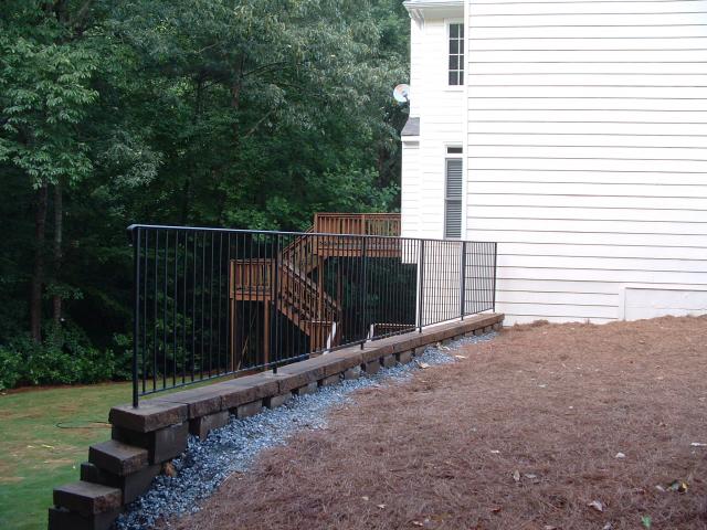 Wrought iron rail for retaining wall